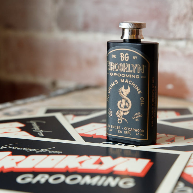 Bottle of Brooklyn Grooming product on a table with branded materials.