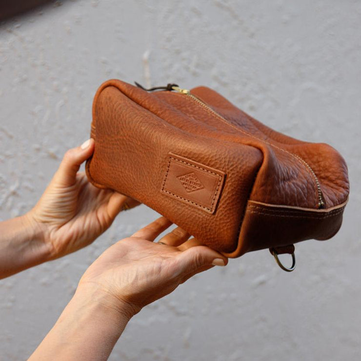 Leather toiletry dopp kit held with patch showing