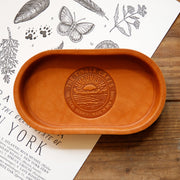 The finger lakes the local branch made in New York leather stamped valet with sun rising over mountains and lake 