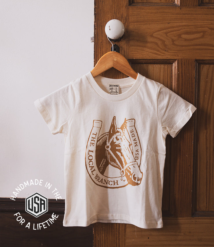 kids cream colored tshirt with brown horse and horseshoe graphic and the local branch USA made