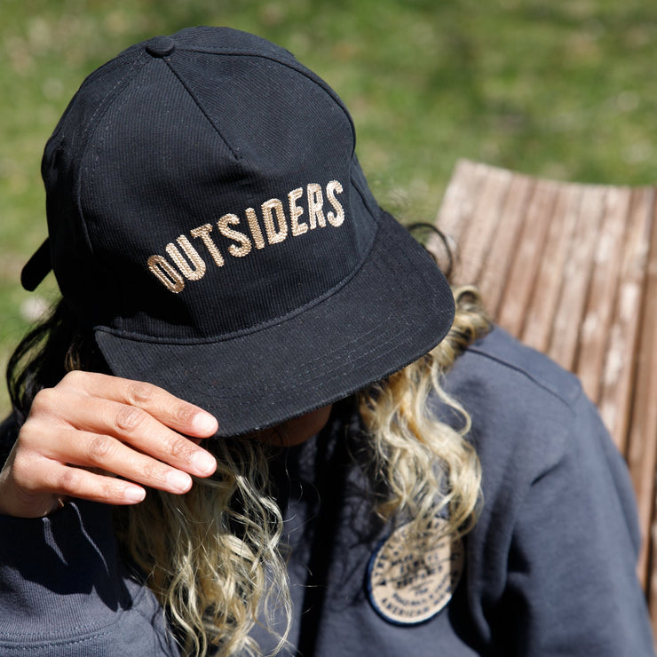 Navy corduroy hat with cream embroidered stitching reading outsiders
Adjustable back 