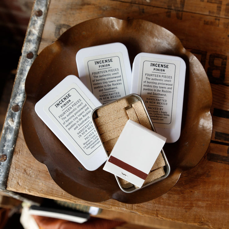 Open tin of pinion incense showing 14 bricks and book of matches