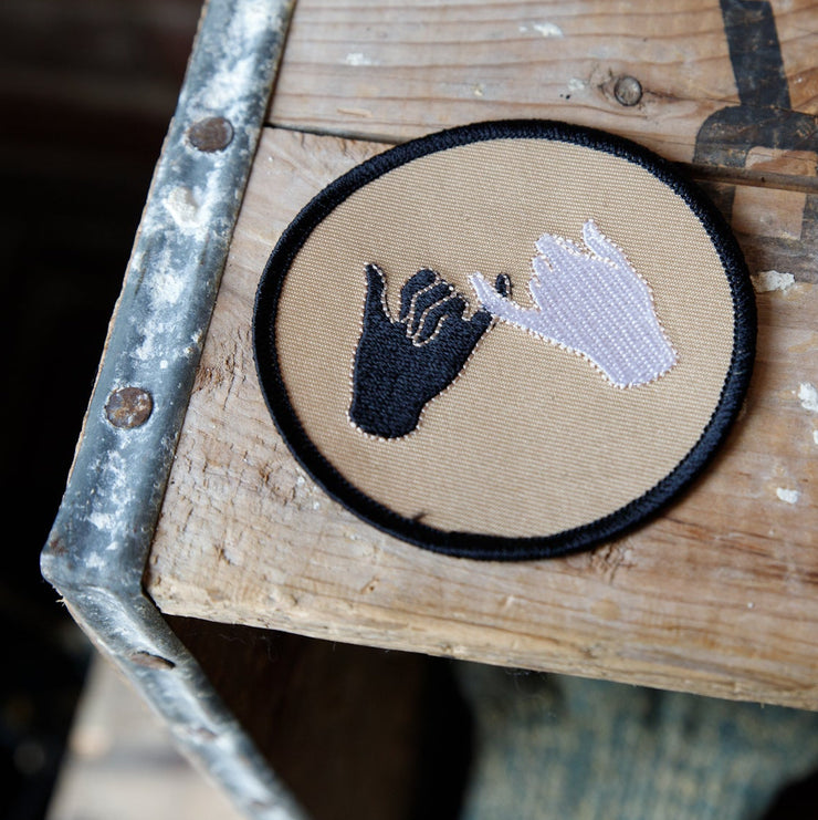 Wooden crate with a patch featuring a hand and shoe design on a blurred background