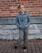 Hard to Say Easy to Love gray hoodie made by The Local Branch worn by a child in front of a brick wall.