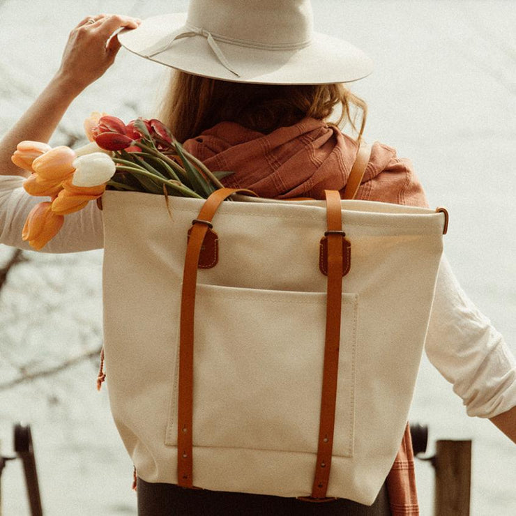 Model at lake wearing canvas backpack tote bag