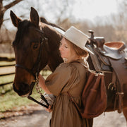 model wearing leather backpack with a horse