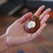 mahogany color leather AirTag key fob with brass hardware