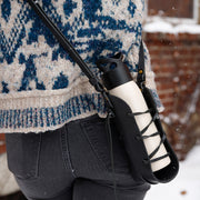 Person wearing a leather laced up bottle sling in black