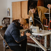 Workshop image of Blaine and Aaron making leather goods