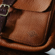 detail shot of bucket and branding on leather sling pack fanny pack