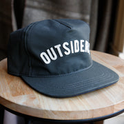 green baseball hat with outsiders stitched on it