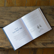 Open book on a wooden surface with text and illustrations.